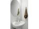 Modern powder room with a pedestal sink, round mirror, and minimalist design at 2312 Oakland Rd, Charleston, SC 29414