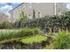 Landscaped backyard with a serene pond, lush greenery, and a glimpse of the home's architecture at 244 Ashley Ave, Charleston, SC 29403