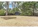 Spacious backyard with potential for gardening, featuring raised beds and mature trees at 244 Ashley Ave, Charleston, SC 29403