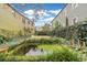 Picturesque backyard featuring a pond, lush landscaping, and charming architecture at 244 Ashley Ave, Charleston, SC 29403