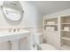 Classic white bathroom with pedestal sink, toilet and built in storage at 244 Ashley Ave, Charleston, SC 29403