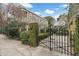 Classic gated entry showcases lush landscaping and a sidewalk view of a meticulously maintained home at 244 Ashley Ave, Charleston, SC 29403