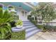 Classic front porch and front entry steps with lush foliage and tasteful flower pots at 244 Ashley Ave, Charleston, SC 29403