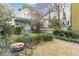 Charming front yard view with lush gardens, complemented by an inviting bench seating and blossoming flowers at 244 Ashley Ave, Charleston, SC 29403