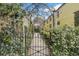 Wrought-iron garden gate leads to a charming courtyard; the perfect welcome to an enchanting property at 244 Ashley Ave, Charleston, SC 29403