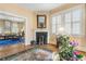 Bright living room featuring fireplace, shutters, hardwood floors and a view into another living space at 244 Ashley Ave, Charleston, SC 29403
