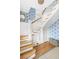 Staircase with wood treads, white risers and banister, and blue floral wallpaper at 244 Ashley Ave, Charleston, SC 29403