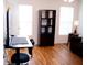 Bright living room with hardwood floors and a modern desk setup by the window at 2590 Otranto Rd, North Charleston, SC 29406