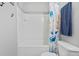 Bright bathroom boasts a white tile shower and tub alongside a nautical themed shower curtain and matching blue towels at 267 Cameron St, Summerville, SC 29486