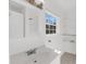 This bathroom features an all-white interior, a window for natural light, a neutral tile floor, and wall shelving at 2969 Bobo Rd, Mount Pleasant, SC 29466