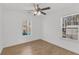 Bright bedroom featuring hardwood floors, a ceiling fan, and natural light through two windows overlooking the backyard at 2969 Bobo Rd, Mount Pleasant, SC 29466