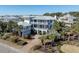 Aerial view of an elegant beach house with multi-level porches and beautifully landscaped grounds at 3030 Marshall Blvd, Sullivans Island, SC 29482