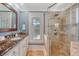 Luxurious bathroom features a glass shower, marble countertops, and a decorative mirror at 3030 Marshall Blvd, Sullivans Island, SC 29482