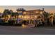 Stunning multi-story home with inviting balconies, lush landscaping, and a brick driveway at twilight at 3030 Marshall Blvd, Sullivans Island, SC 29482