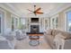 Cozy living room featuring a fireplace, built-in shelves, a ceiling fan, and lots of natural light at 3030 Marshall Blvd, Sullivans Island, SC 29482