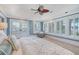 Bright main bedroom with a tray ceiling, plantation shutters, and a cozy seating area at 3030 Marshall Blvd, Sullivans Island, SC 29482