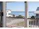 Ocean view through doorway with railings; view of waves, sky and coastline at 3030 Marshall Blvd, Sullivans Island, SC 29482