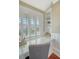 Bright home office with built-in bookshelves, a glass desk, and shuttered windows at 3030 Marshall Blvd, Sullivans Island, SC 29482