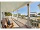 Relaxing porch with rocking chairs offering stunning views of the ocean and nearby homes at 3030 Marshall Blvd, Sullivans Island, SC 29482
