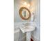 Elegant powder room with pedestal sink, bamboo mirror, and classic wainscoting at 3030 Marshall Blvd, Sullivans Island, SC 29482