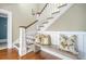 Beautiful staircase with white railing, wood treads, and a comfortable bench adorned with stylish pillows at 3030 Marshall Blvd, Sullivans Island, SC 29482
