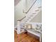 Elegant staircase with white railing, wood treads, and a cozy bench with decorative pillows at 3030 Marshall Blvd, Sullivans Island, SC 29482