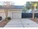 Attached one-car garage featuring a gray door, complemented by a concrete driveway and a black wooden privacy fence at 3049 Park West Blvd, Mount Pleasant, SC 29466