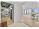 An open living space with a partial view of the kitchen and access to ocean-view patio through large glass windows at 330 Concord St # 7 A, Charleston, SC 29401