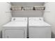 Bright laundry room with white washer and dryer, complemented by storage baskets on a shelf at 350 Arlington Dr, Charleston, SC 29414
