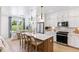 Open kitchen with island seating, white cabinets, stainless appliances, and view of dining area at 351 Claret Cup Way, Charleston, SC 29414