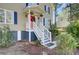 Close-up view of a home's front porch, featuring a red door, hanging plants, and white railing at 3651 Barton St, Johns Island, SC 29455