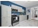 This kitchen offers white marble floors, stainless steel appliances, grey cabinetry and a blue subway tile backsplash at 3651 Barton St, Johns Island, SC 29455