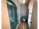 Bathroom featuring a glass-enclosed shower, blue toilet, and patterned wallpaper at 388 Benton Farm Rd, Walterboro, SC 29488
