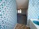 View from the bathroom showcasing the floral wallpaper and entry to the bedroom with a ceiling fan at 388 Benton Farm Rd, Walterboro, SC 29488