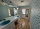 Bathroom featuring double sinks, blue patterned wallpaper, and a vintage aesthetic at 388 Benton Farm Rd, Walterboro, SC 29488