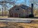 This two-story brick home features a two-car garage and mature trees on a sunny day at 388 Benton Farm Rd, Walterboro, SC 29488