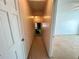 View of a hallway with access to the attic and a bedroom with neutral carpet and white walls at 388 Benton Farm Rd, Walterboro, SC 29488