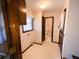 Hallway with tiled flooring leading to a window with blinds and access to a bathroom at 388 Benton Farm Rd, Walterboro, SC 29488