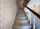 Carpeted staircase featuring a wooden handrail and floral wallpaper creates a classic look at 388 Benton Farm Rd, Walterboro, SC 29488