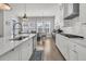 Open concept kitchen with white cabinets, island with sink, and view to the dining area, great for entertaining at 3920 Maidstone Dr, Mount Pleasant, SC 29466
