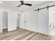 A bedroom featuring modern vinyl floors, a ceiling fan, and a barn door to the attached bathroom at 397 Parkdale Dr, Charleston, SC 29414