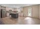Open kitchen with stainless appliances, island, and wooden cabinets on wood-look floors at 421 Peacock Ln, Summerville, SC 29486