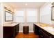 Bright bathroom with dual sinks, dark wood cabinets, and wood floors at 4333 Cloudmont Dr, Hollywood, SC 29449