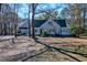 Charming home with light blue siding and a red front door surrounded by natural trees at 4333 Cloudmont Dr, Hollywood, SC 29449