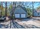 A large two car garage with upper level access and a light blue facade with natural setting at 4333 Cloudmont Dr, Hollywood, SC 29449