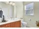 Bathroom with a single sink vanity, toilet, mirror, and a window for natural lighting at 4610 Palm View Cir, North Charleston, SC 29418