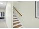 Well-lit staircase with wooden steps and a painted white handrail at 4610 Palm View Cir, North Charleston, SC 29418