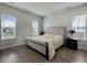 Cozy bedroom features a tufted headboard bed, windows for natural light, and hardwood flooring at 500 W Respite Ln, Summerville, SC 29483