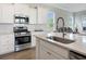 Kitchen features stainless steel appliances, white cabinets, and a kitchen island with bar seating at 500 W Respite Ln, Summerville, SC 29483