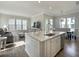 Open-concept living room featuring a modern kitchen island, living area with large windows, and comfortable seating at 500 W Respite Ln, Summerville, SC 29483